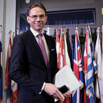 Jyrki Katainen, holding his smartphone